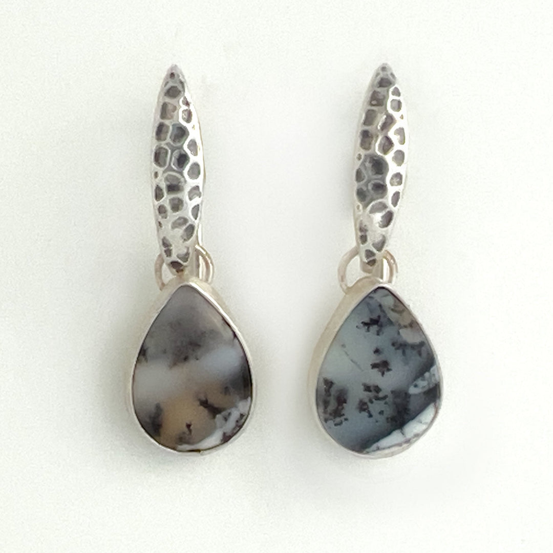 Dendritic Opals are known for their unique and intricate patterns, reminiscent of natural landscapes. This one-of-a-kind pair of earrings boasts distinct patterns of each stone offering a harmonious balance and showcasing individuality. Crafted for confident women, these earrings are a statement piece. 