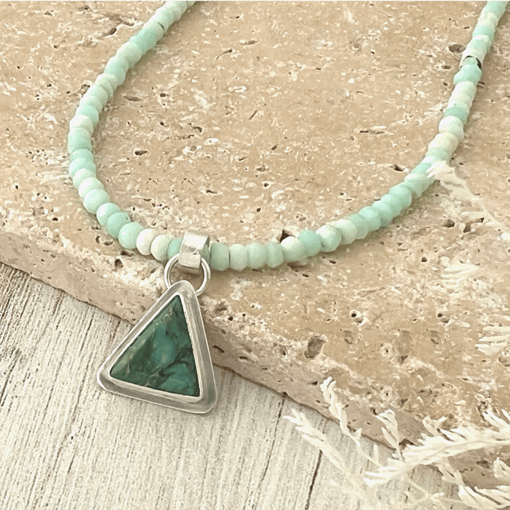 Handcrafted Peruvian Blue Opal necklace with triangular Crescent Lake Variscite pendant set in sterling silver on stone background.