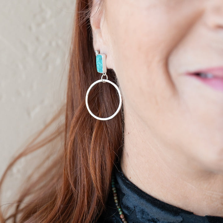 Turn heads with these one-of-a-kind Turquoise stud hoops, crafted with sterling silver and adorned with natural Turquoise.  Front View.